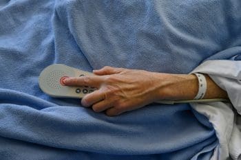 nursing home patient with hand on a call buzzer