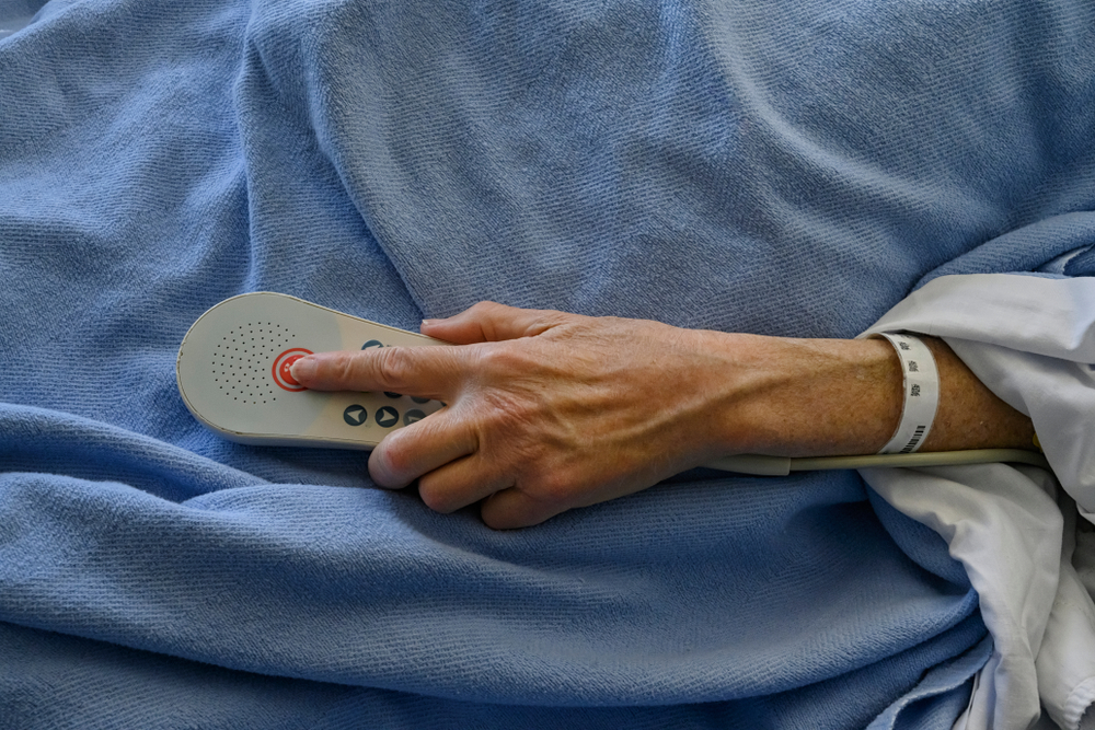 nursing home patient with hand on a call buzzer