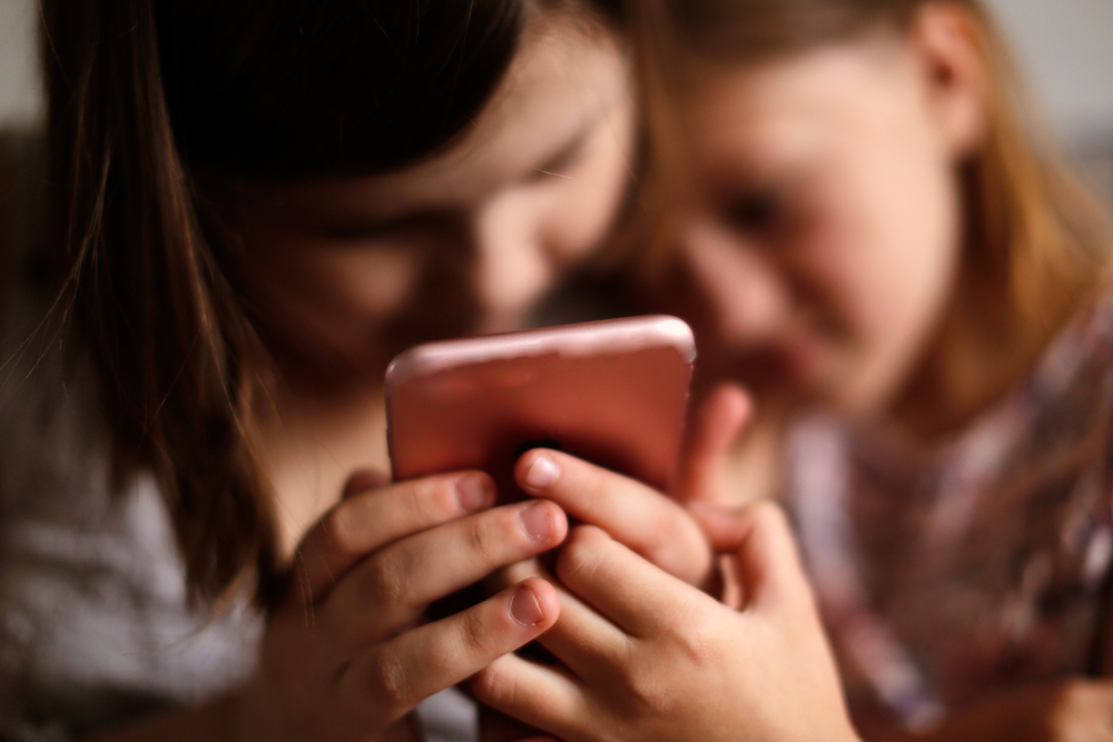 children using social media on a phone