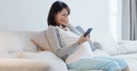 Pregnant woman looking at her phone